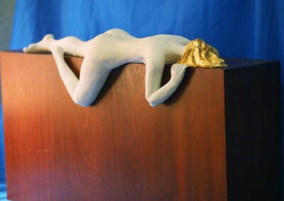 Escultura de mujer desnuda tumbada en relajación
