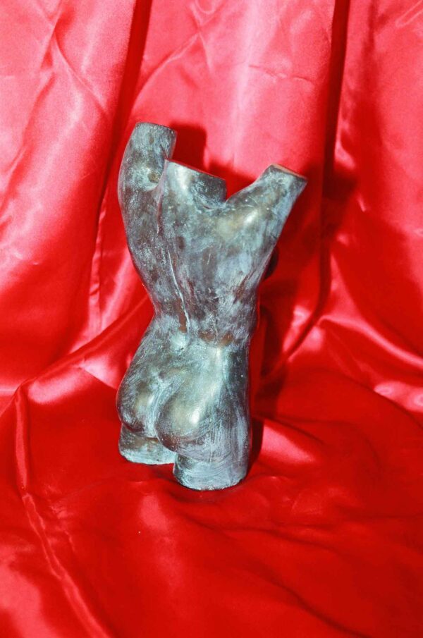 Escultura de una mujer desnuda con los brazos en alto