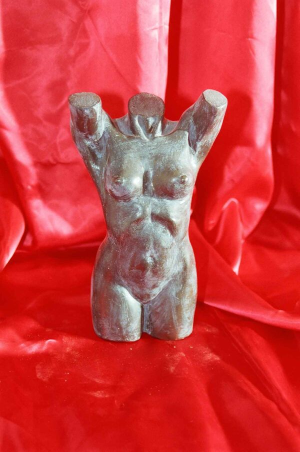 Escultura de una mujer desnuda con los brazos en alto